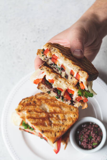 istock Grilled cheese sandwiches with vegetables and olive paste in hand. 1302253465