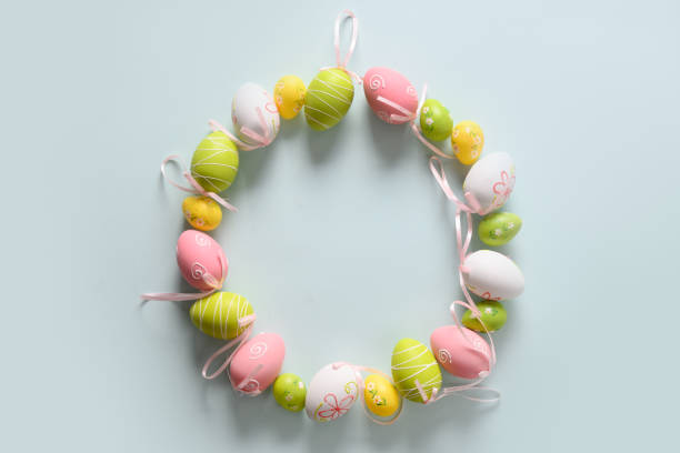 istock Easter wreath of colorful pastel eggs on blue. 1302254822
