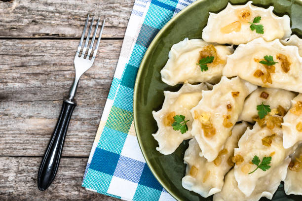 istock Homemade dumplings with fried onion on plate, top view, cooking concept 1302254854