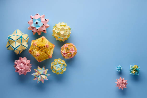 set of multicolorâ handmade modularâ origami balls or kusudama isolated on blue background. visual art, geometry, art of paper folding, paper crafts. top view, close up, selective focus, copy space. - kusudama imagens e fotografias de stock