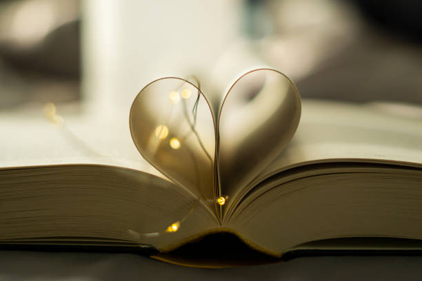 istock Heart-shaped Folded Book Art with fairy lights - valentine's day 1302256129