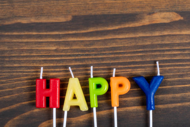 istock Happy. Colored anniversary candles on a wooden background 1302256142