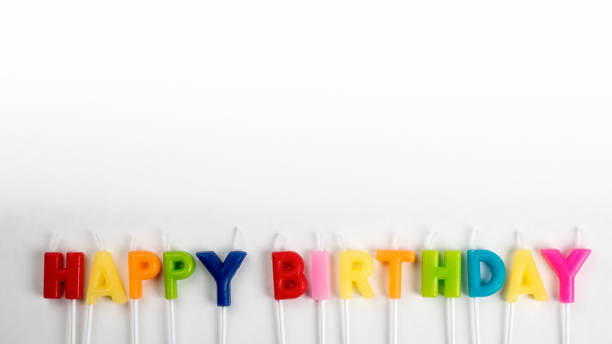 Happy Birthday. Colored anniversary candles. White panoramic banner background with copy space