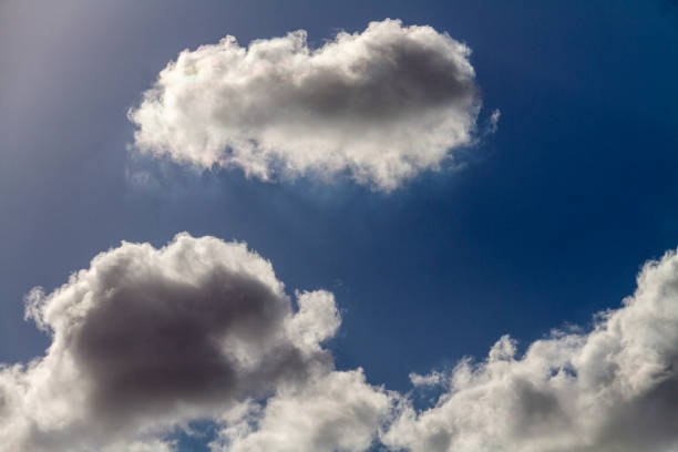 istock Beautiful puffy clouds in the sun on a blue sky. 1302257179