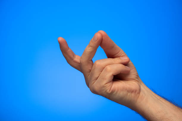 Caucasian male hand making a finger snap gesture studio shot isolated on blue background Caucasian male hand making a finger snap gesture studio shot isolated on blue background. click finger stock pictures, royalty-free photos & images