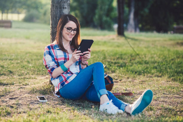 seul dans la nature - women grass glasses e reader photos et images de collection