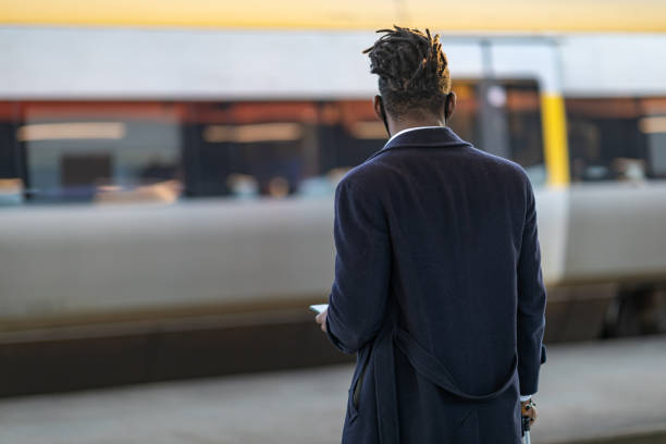 istock Man at a train station using a smartphone 1302257758