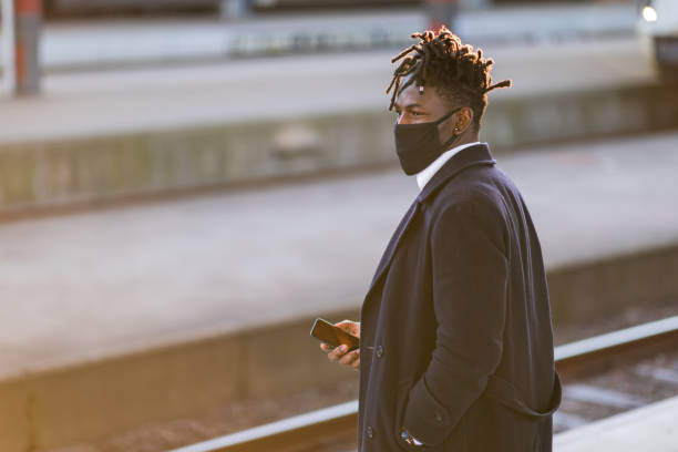 istock Man at a train station using a smartphone 1302257858