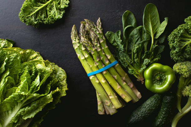 istock Dark culinary background with asparagus and fresh green vegetables produce 1302262900