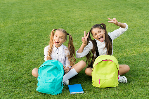 Group study outdoors girls classmates with backpacks, playful children concept.