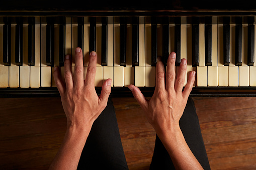 Close-up of a man's hand playing piano