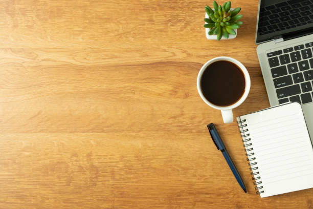 istock Flat lay of Office desk with laptop, and blank notepad with a coffee cup on wood table 1302265733