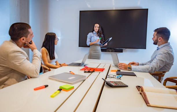 istock Female speaker telling something to audience and holding documents. 1302266914