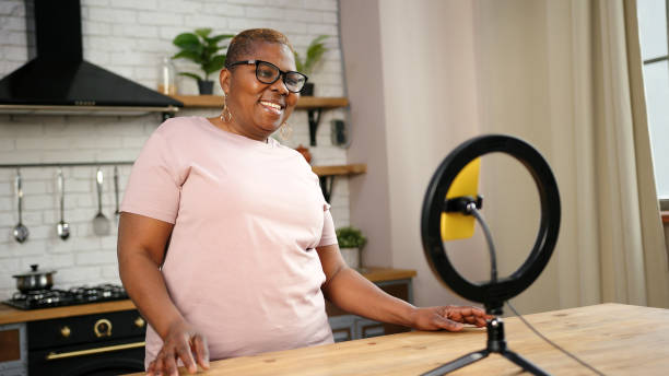 istock African-American lady blogger talks looking into smartphone 1302268992