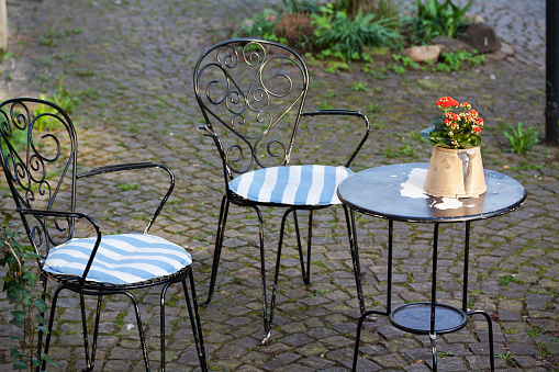 Small metal table and chairs of bistro outdoors on cobblestone