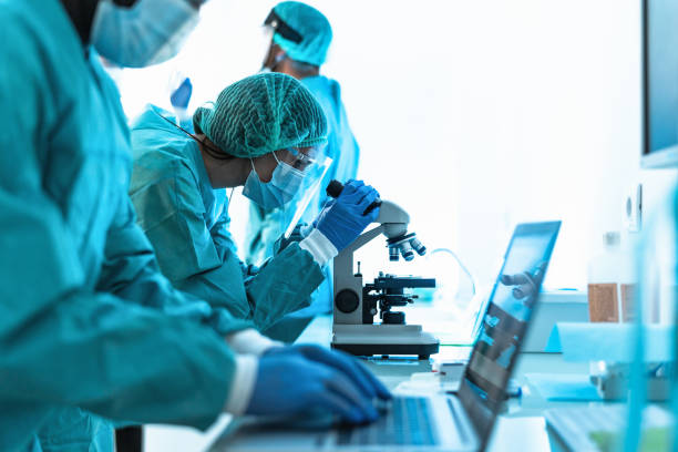 trabajadores médicos haciendo análisis en laboratorio durante brote de virus corona- concepto de ciencia y salud - biotecnología fotografías e imágenes de stock