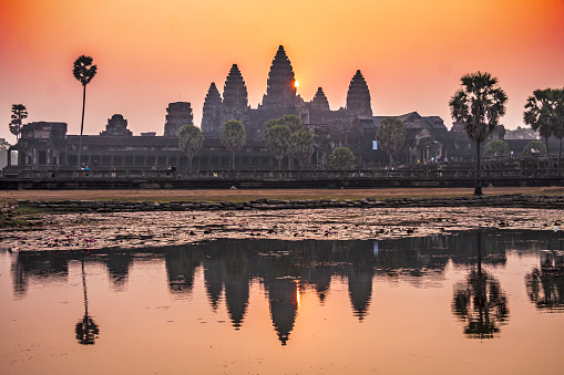 Cambodia - Angkor - Soft morning silhuette of Angkor Wat, monumental temple complex and UNESCO world heritage, in sunrise with its reflection in pond water