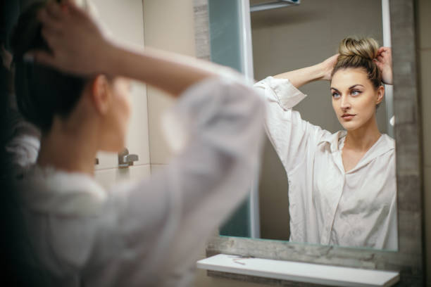 istock Young woman doing hairstyle in mirror reflection 1302277261