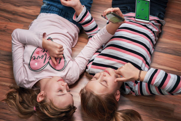 istock Little Girls Using Smartphone with Green Screen 1302277918