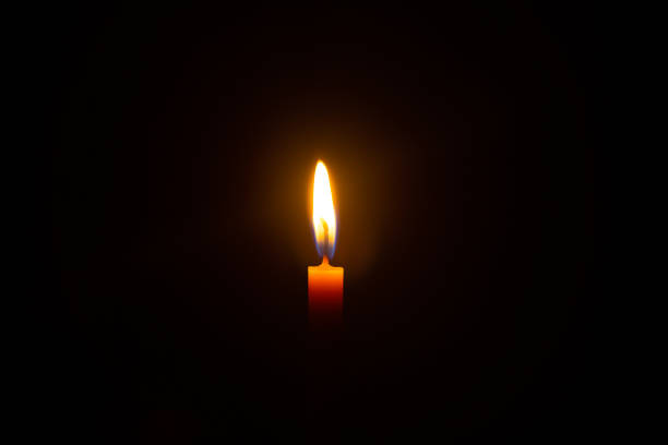 istock One light candle burning brightly in the black background 1302278778