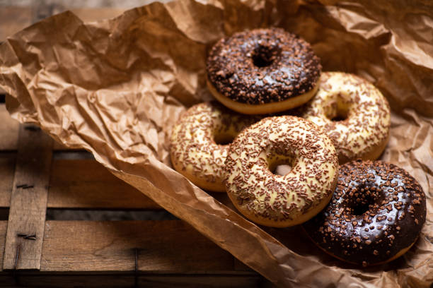 Sweet donuts with chocolate sprinkles dessert wrapped in a paper top view