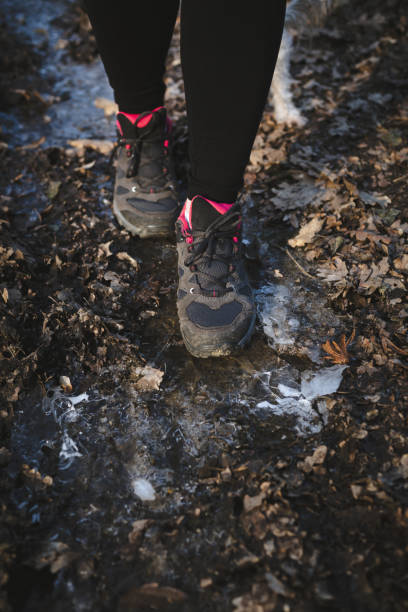 Active woman walking on frozen ground, close up Close up of female sport shoes on frozen ground in the woods. Active woman jogging in winter time. slippery unrecognizable person safety outdoors stock pictures, royalty-free photos & images