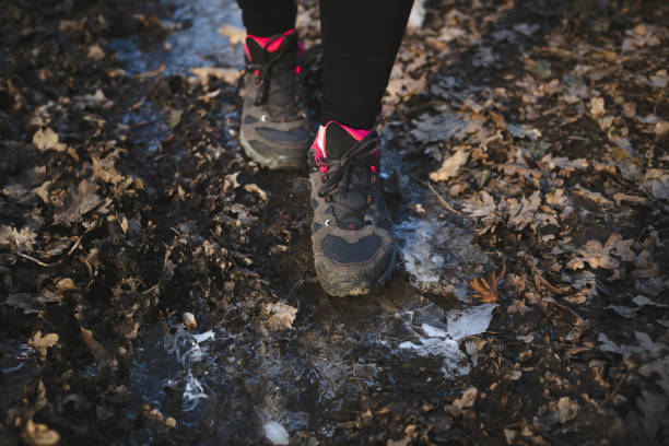 Active woman walking on frozen ground, close up Close up of female sport shoes on frozen ground in the woods. Active woman jogging in winter time. slippery unrecognizable person safety outdoors stock pictures, royalty-free photos & images