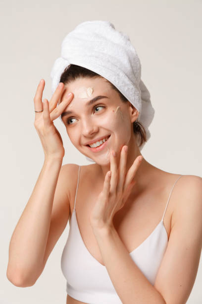 beauty treatment - woman applying moisturing creame - massage creme imagens e fotografias de stock