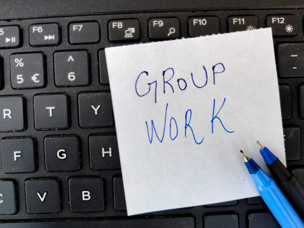 istock A White sticky note with text GROUP WORK and two pens on top of laptop keyboard 1302280660