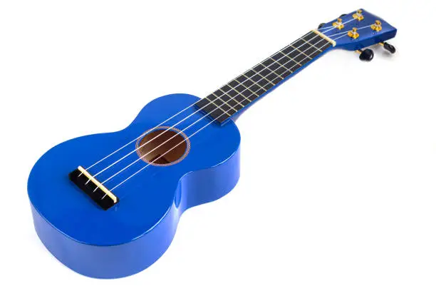 Photo of Guitar musical instrument in blue on a white background. Ukulele. Isolate.