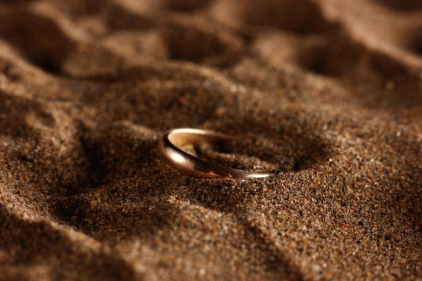 istock golden ring close-up on the beach sand 1302282241
