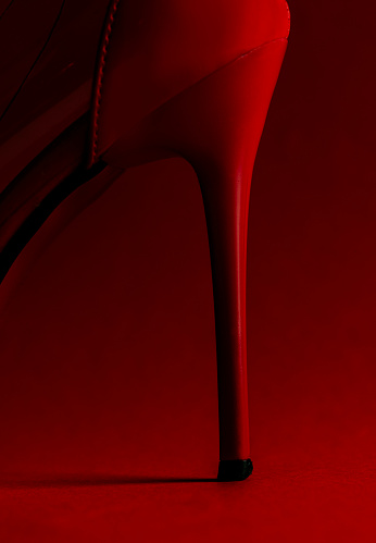 Close-up of red high heel against red background.