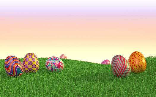 Cute decorated Easter eggs are lying on the grass under a clear sky at sunset. Easy to crop for all social media and print design sizes.