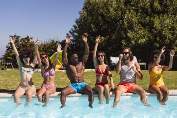 istock Diverse group of friends smiling and sitting at the poolside 1302284584