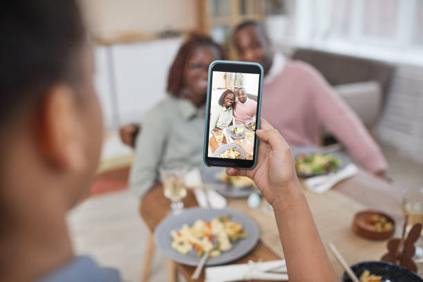 istock Modern African American Family Taking Photos at Dinner Table 1302285764
