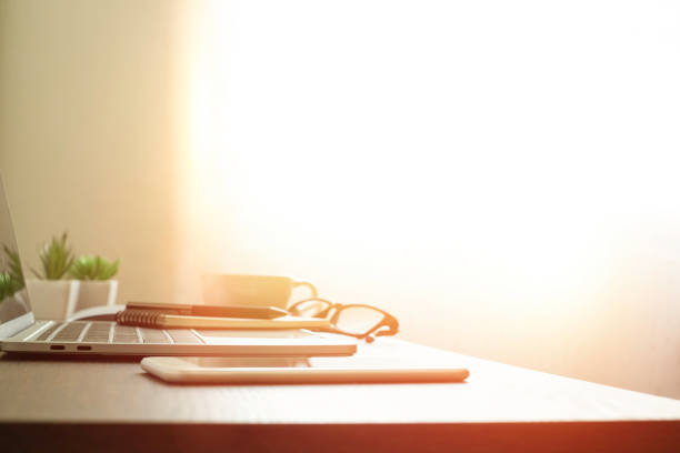 istock soft focus of Office desk table with keyboard of laptop computer, coffee cup and notebook, glasses. Business and finance concept. Workplace with morning sunlight from window with copy space. 1302286207