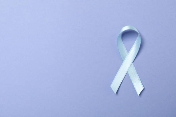 istock Light blue awareness ribbon on light violet background 1302286491
