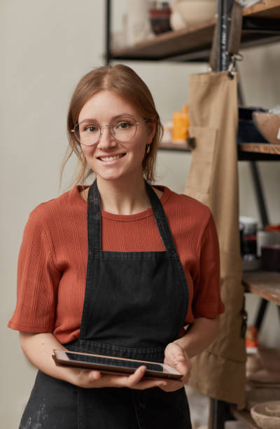 istock Smiling Young Woman Wearing Apron in Workshop 1302287636