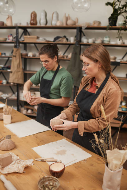 istock Young People Shaping Clay in Pottery Workshop 1302287701
