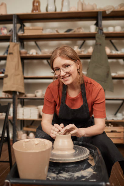 istock Smiling Woman Making Ceramics on Pottery Wheel 1302287739
