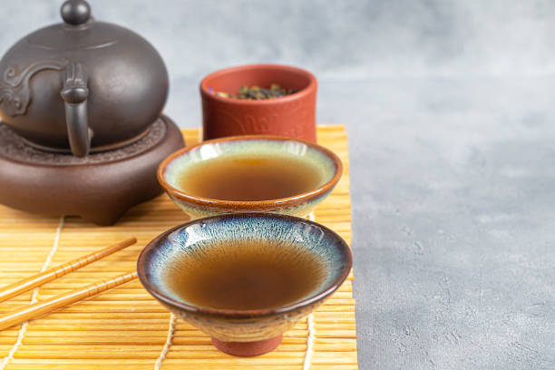 teezeremonie. chinesische pu-erh in einer schüssel. im hintergrund ist eine braune teekanne und teeblätter. - italian dessert audio stock-fotos und bilder