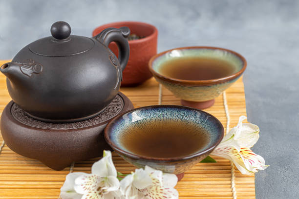 teezeremonie. chinesische pu-erh in einer schüssel. im hintergrund ist eine braune teekanne und teeblätter. - italian dessert audio stock-fotos und bilder