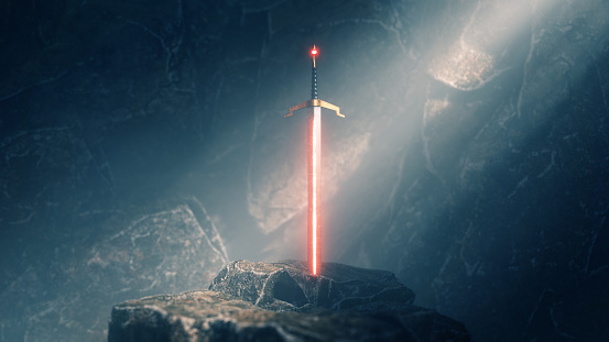 sword in the stone with light rays and dust specs in a dark cave