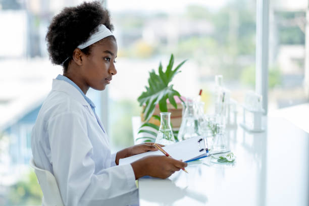 istock African American young hold clipboard or document file and look to right side during do experiment 1302291299