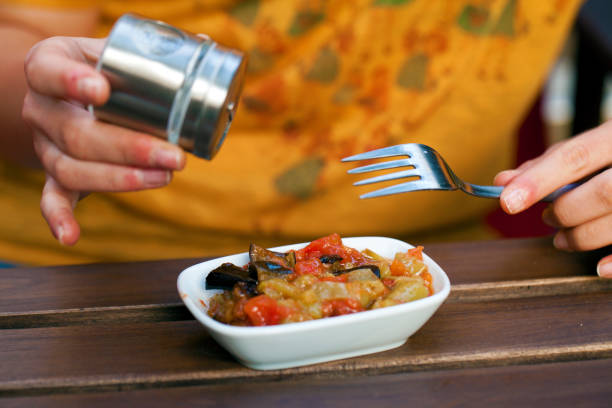 istock Girl is adding Salt to Meal 1302292705