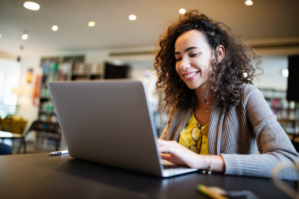 istock Young beautiful student girl working, learning in college library 1302293378