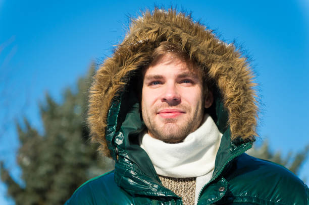 Man unshaven wear warm jacket with fur snowy nature background. Guy wear winter jacket with furry hood. Hipster winter fashion. Prepared for weather changes. Winter stylish menswear. Winter outfit. hombre sin afeitar usar chaqueta caliente con piel de fondo de naturaleza nevada. el tipo usa chaqueta de invierno con capucha peluda. moda hipster de invierno. preparado para los cambios climáticos. ropa de hombre elegante de invierno. traje de invierno