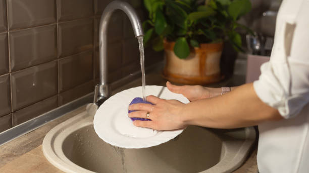 istock Woman washing plate in modern kitchen. 1302295514