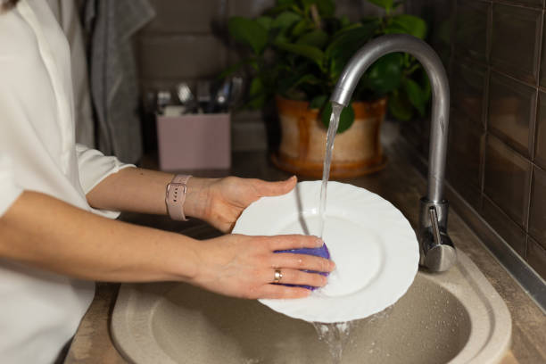 istock Woman washing plate in modern kitchen. 1302295532