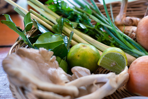 Oyster mushroom, galangal, shallot, lemon grass, cilantro, kaffir lime leaves and scallion.  Close-up food background.